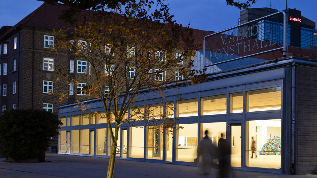 Kvällsbild av Malmö Konsthalls fönster mot Magistratsparken.