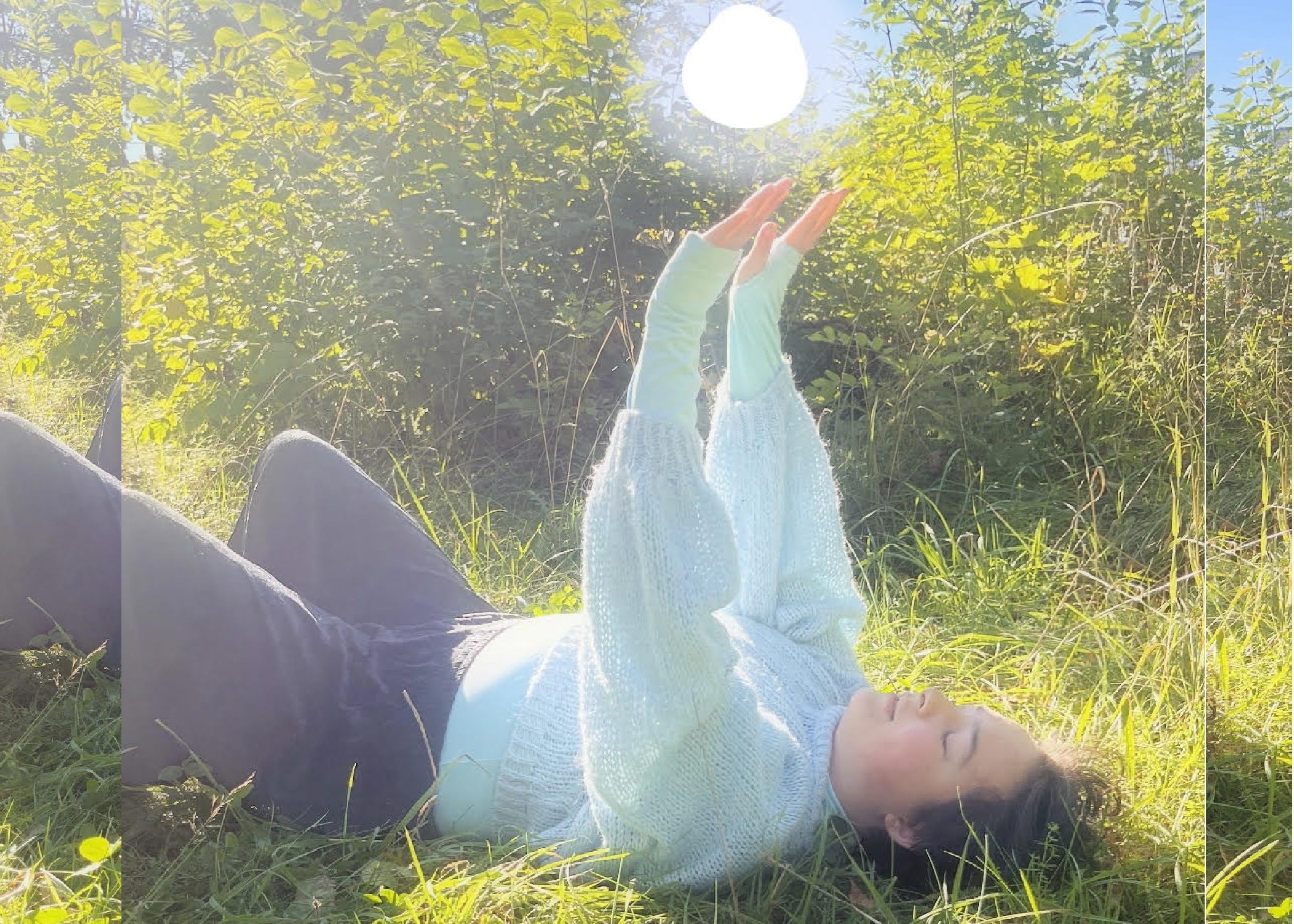 En person ligger ner på rygg i gräset men armarna uppsträckta mot himlen. Personen har vit tröja och svarta byxor på sig.