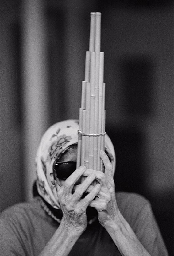 Black-and-white image of the artist CC Hennix playing a reed wind instrument.