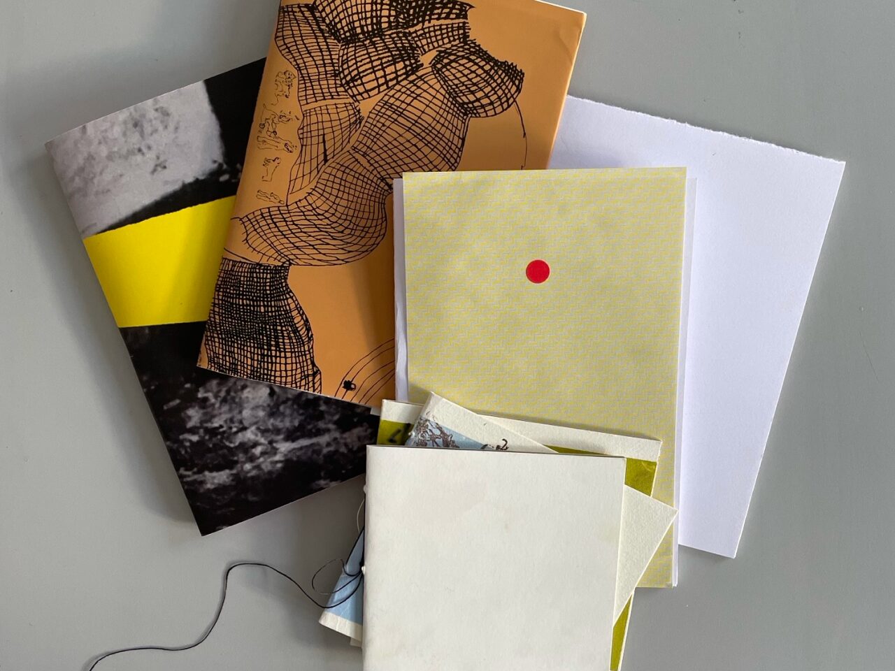 Bild på hemmagjorda böcker i olika ljusa färger.