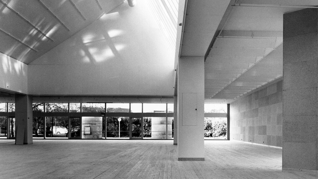 Konsthallens interiör vid öppnandet 1975. Tidig svartvit bild av konsthallens stora ljusa rum, man ser delar av originalinredningen med kork på väggarna.
