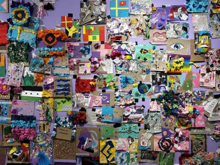 Lila vägg fylld med flera färgglada verk i papper och kartong.