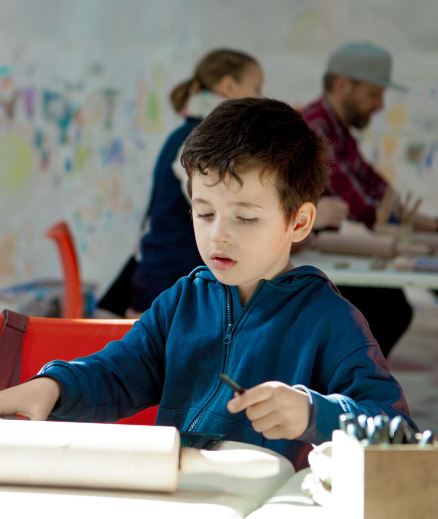 Liten pojke sitter och skapar i Verkstan.