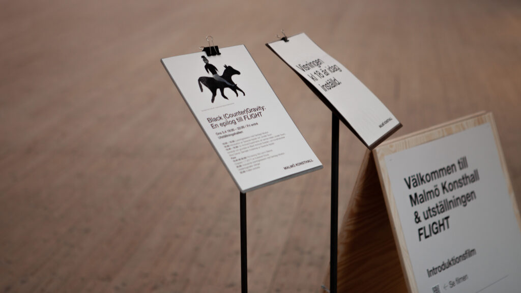 Different information signs stand next to each other in the art gallery.