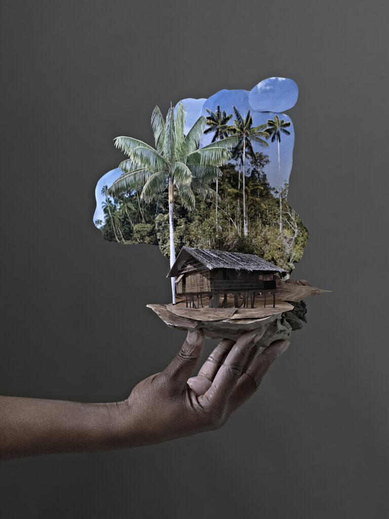 Fotografi/skulpturalt verk av Otobong Nkanga. En hand håller en liten skulptur konstruerad av collage och naturmaterial.